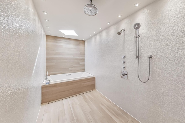 870 Woodbine Rd, Highland Park, IL 60035 - full bathroom featuring a skylight, a garden tub, recessed lighting, a tile shower, and wood finished floors