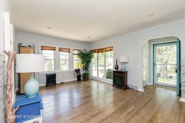 1826 Ohio Pkwy, Rockford, IL 61108 - exercise area featuring arched walkways, wood finished floors, a wood stove, and a fireplace