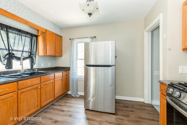 1826 Ohio Pkwy, Rockford, IL 61108 - kitchen featuring freestanding refrigerator, gas stove, dark wood-type flooring, dark countertops, and brown cabinets