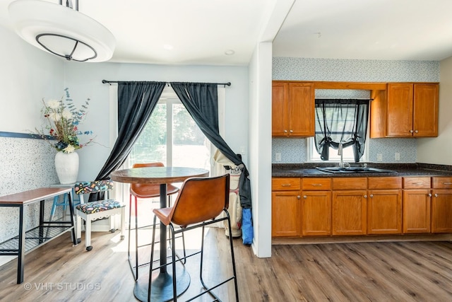 1826 Ohio Pkwy, Rockford, IL 61108 - kitchen featuring brown cabinets, wood finished floors, wallpapered walls, and decorative backsplash
