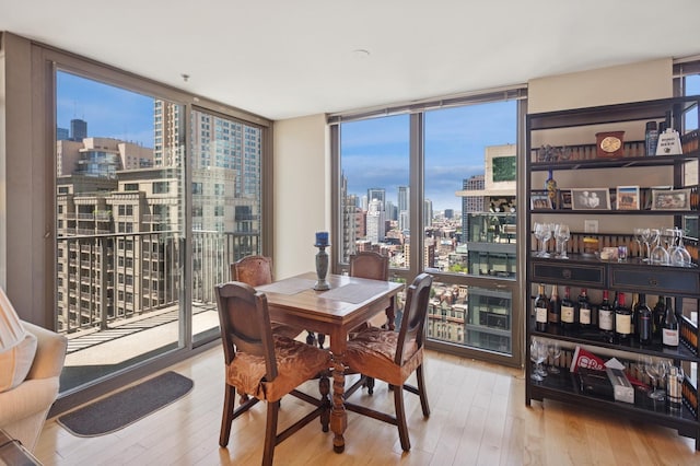 2 E Erie St Unit 2505, Chicago, IL 60611 - dining area featuring a skyline view, hardwood / wood-style flooring, floor to ceiling windows, and a bar