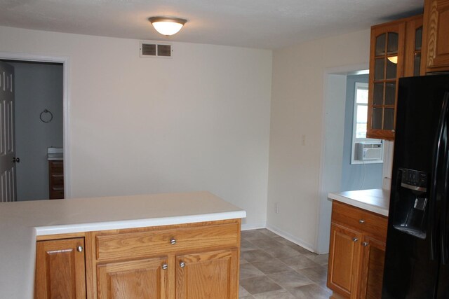 517 Victor St, Sycamore, IL 60178 - kitchen featuring black refrigerator with ice dispenser, light countertops, glass insert cabinets, cooling unit, and brown cabinets