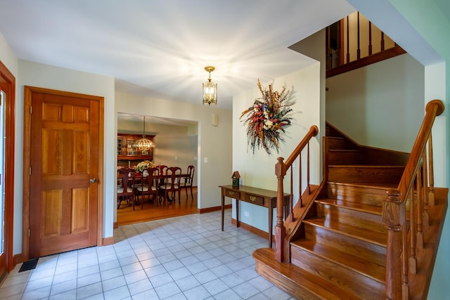 215 Hilltop Ln, Sleepy Hollow, IL 60118 - entryway featuring a chandelier, stairway, light tile patterned floors, and baseboards