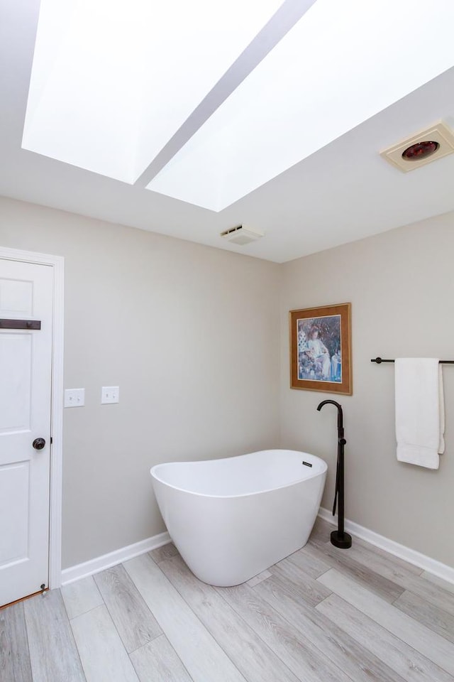 215 Hilltop Ln, Sleepy Hollow, IL 60118 - full bathroom featuring a skylight, a soaking tub, wood finished floors, and baseboards
