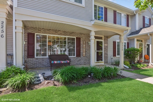 2258 Reflections Dr Unit 2258, Aurora, IL 60502 - doorway to property featuring brick siding, covered porch, and a lawn