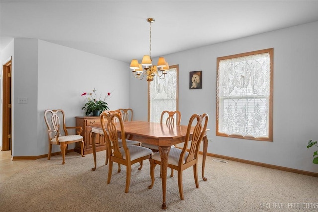 1705 Heatherstone Ave, Montgomery, IL 60538 - dining area featuring a chandelier, light colored carpet, and baseboards