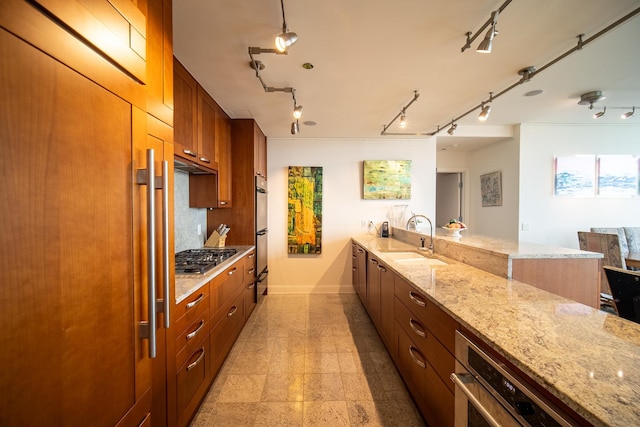 340 E Randolph St Unit 4703, Chicago, IL 60601 - kitchen with a sink, baseboards, stainless steel gas stovetop, light stone countertops, and a peninsula