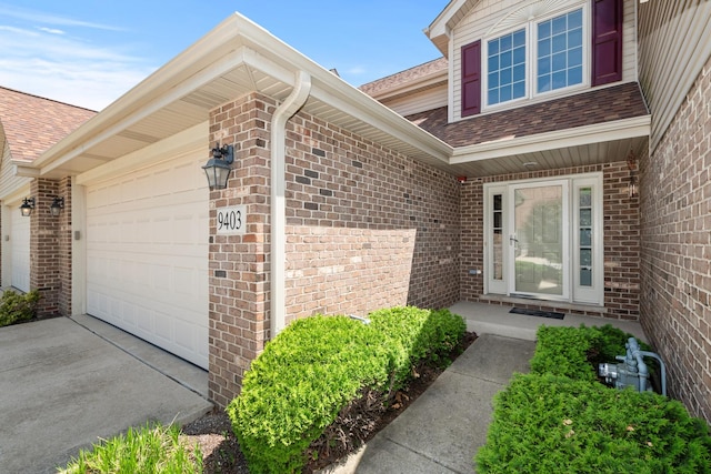 9403 Saratoga Ct, Hickory Hills, IL 60457 - view of exterior entry featuring a garage, brick siding, roof with shingles, and concrete driveway