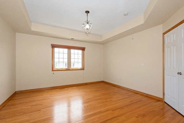9403 Saratoga Ct, Hickory Hills, IL 60457 - spare room with a raised ceiling, light wood-style floors, baseboards, and a chandelier