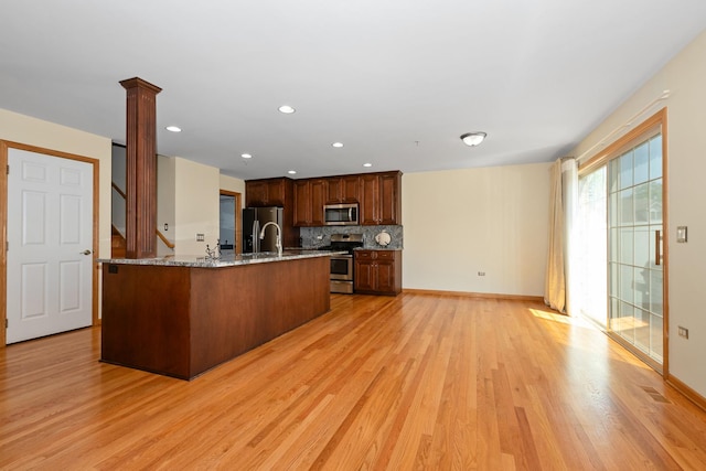 9403 Saratoga Ct, Hickory Hills, IL 60457 - kitchen with appliances with stainless steel finishes, light wood-style flooring, backsplash, light stone countertops, and baseboards