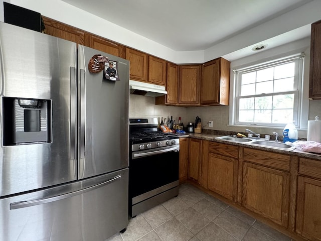 14812 S Wabash Ave, Dolton, IL 60419 - kitchen featuring stainless steel appliances, under cabinet range hood, brown cabinets, a sink, and light tile patterned flooring