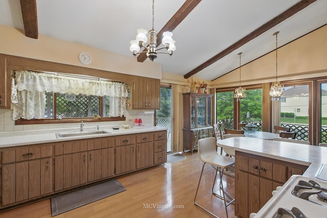 6542 S Ridge Rd, Willowbrook, IL 60527 - kitchen with a chandelier, a sink, light countertops, and decorative backsplash