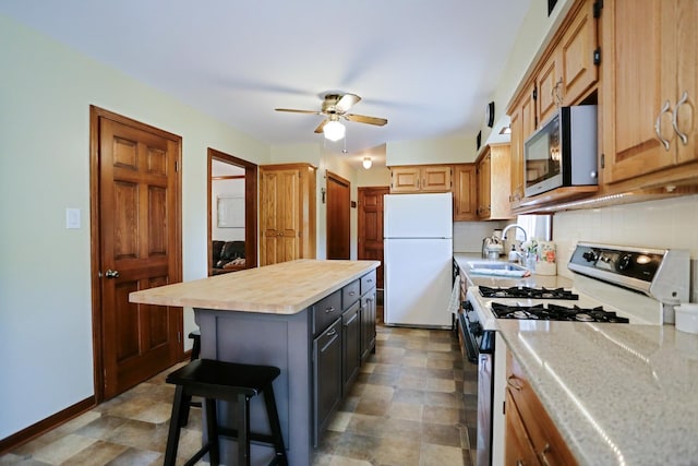 611 S 10th Ave, Saint Charles, IL 60174 - kitchen featuring freestanding refrigerator, gas stove, stainless steel microwave, a ceiling fan, and backsplash