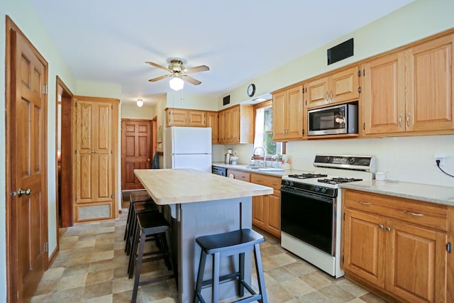611 S 10th Ave, Saint Charles, IL 60174 - kitchen with white appliances, light countertops, a breakfast bar area, ceiling fan, and a kitchen island