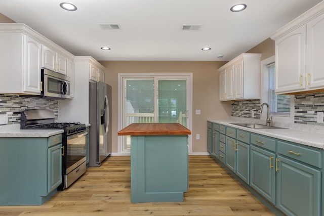 3708 W 162nd Pl, Markham, IL 60428 - kitchen with appliances with stainless steel finishes, white cabinets, light wood-type flooring, backsplash, and a center island