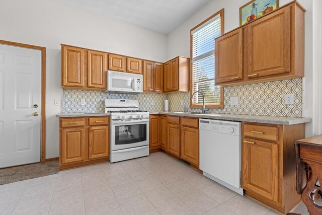 12169 Ayrshire Ln, Loves Park, IL 61111 - kitchen featuring white appliances, a sink, light countertops, brown cabinets, and decorative backsplash