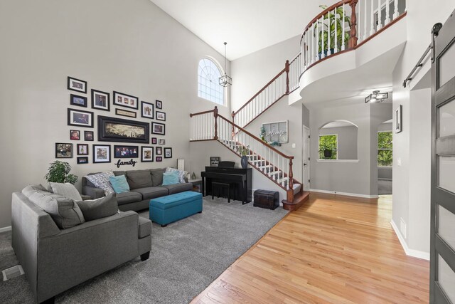 1284 Mcdole Dr, Sugar Grove, IL 60554 - living area featuring light wood finished floors, a towering ceiling, stairs, healthy amount of natural light, and baseboards