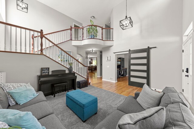 1284 Mcdole Dr, Sugar Grove, IL 60554 - living area with a high ceiling, a chandelier, a barn door, wood finished floors, and stairs