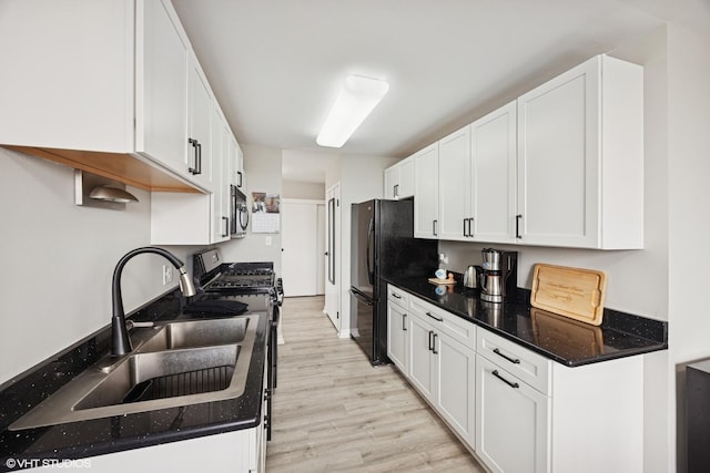 20 N Tower Rd Unit 3G, Oak Brook, IL 60523 - kitchen featuring gas range oven, a sink, freestanding refrigerator, light wood-type flooring, and white cabinetry