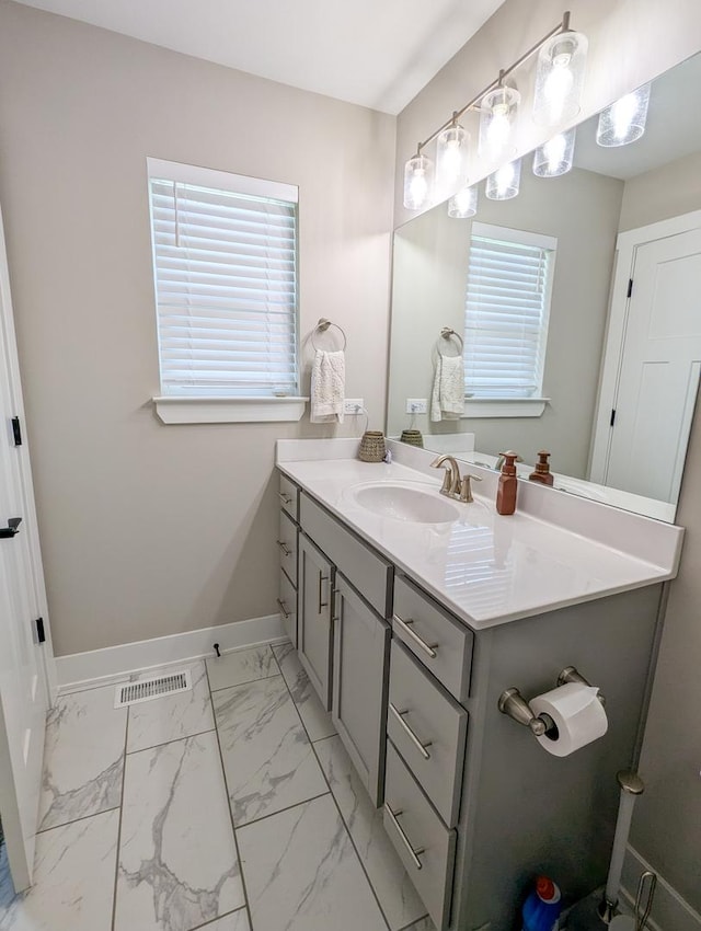 1785 Condor Dr, Manteno, IL 60950 - bathroom featuring vanity, healthy amount of natural light, baseboards, and marble look tiles