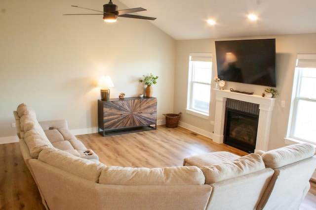 1785 Condor Dr, Manteno, IL 60950 - living area featuring a ceiling fan, a glass covered fireplace, wood finished floors, baseboards, and lofted ceiling