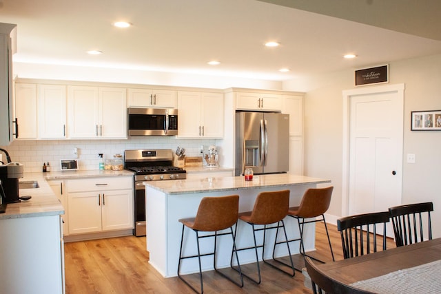 1785 Condor Dr, Manteno, IL 60950 - kitchen with stainless steel appliances, backsplash, a breakfast bar, a center island, and recessed lighting
