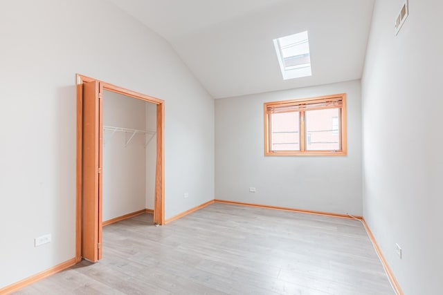 2413 W Taylor St, Chicago, IL 60612 - unfurnished bedroom featuring a skylight, lofted ceiling, light wood-style floors, a spacious closet, and baseboards