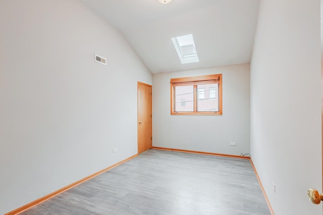 2413 W Taylor St, Chicago, IL 60612 - unfurnished room featuring a skylight, vaulted ceiling, light wood-style flooring, and baseboards