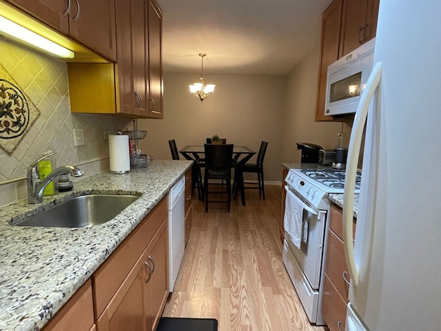 1188 Royal Glen Dr Unit 211, Glen Ellyn, IL 60137 - kitchen featuring white appliances, a sink, light wood-type flooring, decorative backsplash, and brown cabinets