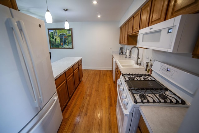 7902 160th St, Tinley Park, IL 60477 - kitchen featuring white appliances, a sink, brown cabinets, light countertops, and light wood finished floors