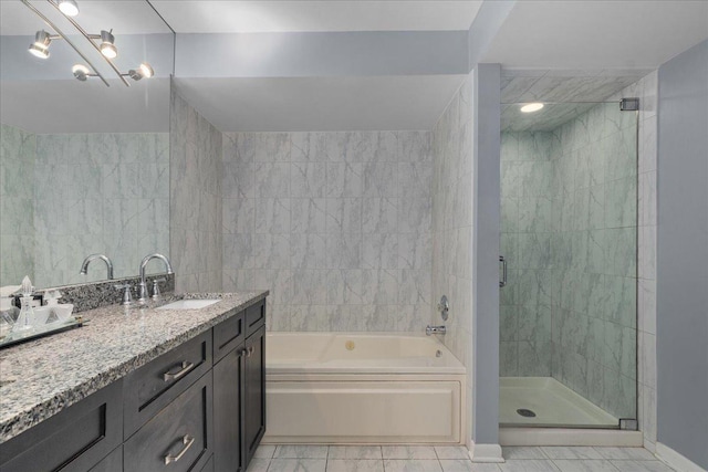 1534 Mcdaniels Ave Unit 4B, Highland Park, IL 60035 - bathroom featuring vanity, a garden tub, a stall shower, tile patterned flooring, and baseboards