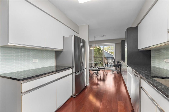 1534 Mcdaniels Ave Unit 4B, Highland Park, IL 60035 - kitchen featuring appliances with stainless steel finishes, white cabinetry, dark wood-style flooring, and dark stone counters