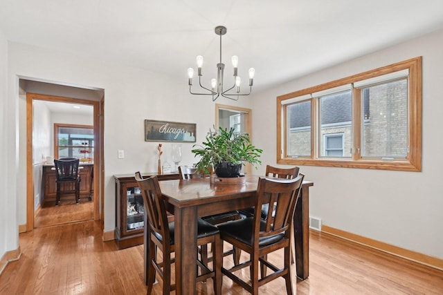 7517 N Oketo Ave, Chicago, IL 60631 - dining area featuring a chandelier, baseboards, and light wood-style floors