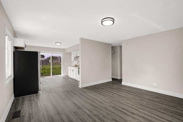 232 Camden Dr, Steger, IL 60475 - unfurnished living room with dark wood-style flooring and baseboards