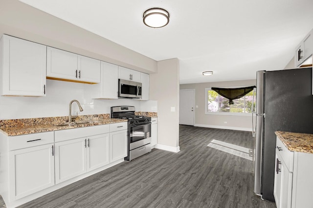 232 Camden Dr, Steger, IL 60475 - kitchen with stainless steel appliances, a sink, dark wood-type flooring, light stone countertops, and white cabinetry