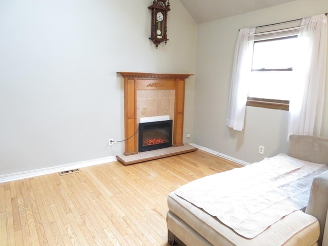 2020 Greengold St, Crest Hill, IL 60403 - bedroom featuring wood finished floors, baseboards, a tile fireplace, and lofted ceiling