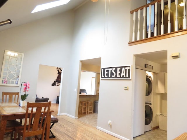 2020 Greengold St, Crest Hill, IL 60403 - dining room featuring stacked washing machine and dryer, high vaulted ceiling, wood finished floors, and baseboards