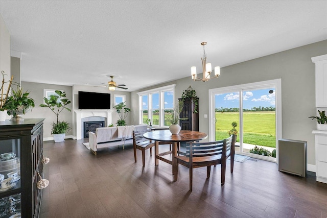 1908 Littlefield Ln, Mahomet, IL 61853 - dining space with a glass covered fireplace, ceiling fan, dark wood-style floors, a chandelier, and a textured ceiling