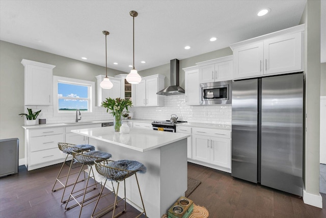 1908 Littlefield Ln, Mahomet, IL 61853 - kitchen featuring appliances with stainless steel finishes, wall chimney exhaust hood, a sink, white cabinets, and backsplash