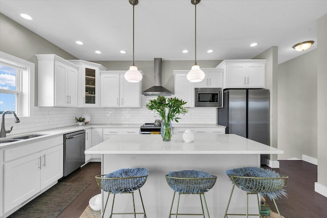 1908 Littlefield Ln, Mahomet, IL 61853 - kitchen with wall chimney exhaust hood, stainless steel appliances, a sink, a breakfast bar area, and decorative backsplash