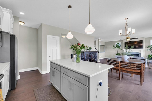 1908 Littlefield Ln, Mahomet, IL 61853 - kitchen featuring baseboards, dark wood-type flooring, a chandelier, open floor plan, and a kitchen island