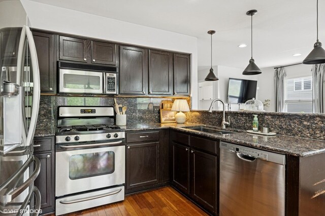 2834 Forestview Dr, Carpentersville, IL 60110 - kitchen with stainless steel appliances, a sink, a peninsula, dark wood finished floors, and tasteful backsplash