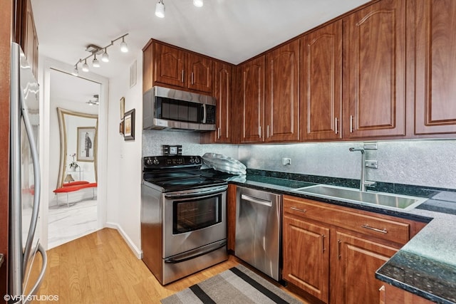 505 N Lake Shore Dr Unit 5201, Chicago, IL 60611 - kitchen featuring stainless steel appliances, a sink, light wood-style flooring, dark stone countertops, and track lighting
