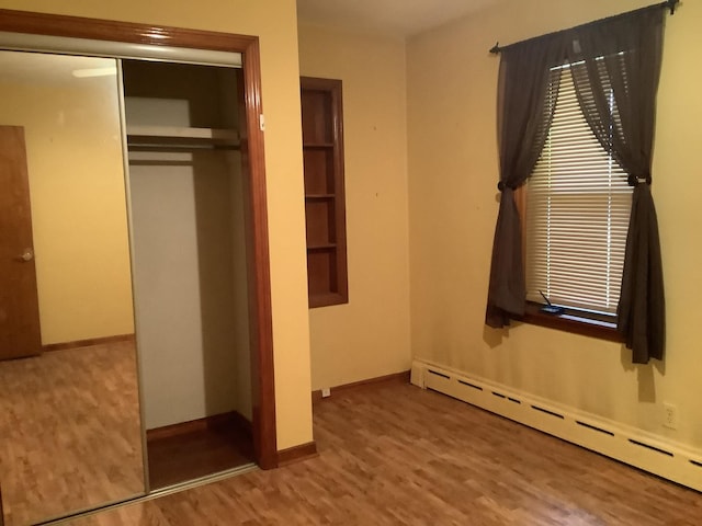 404 W Francis Rd, New Lenox, IL 60451 - unfurnished bedroom featuring a baseboard radiator, wood finished floors, a closet, and baseboards