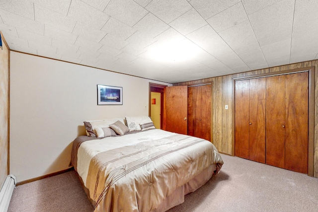 143 Scott Dr, East Dundee, IL 60118 - bedroom with a baseboard radiator, carpet floors, wood walls, and multiple closets