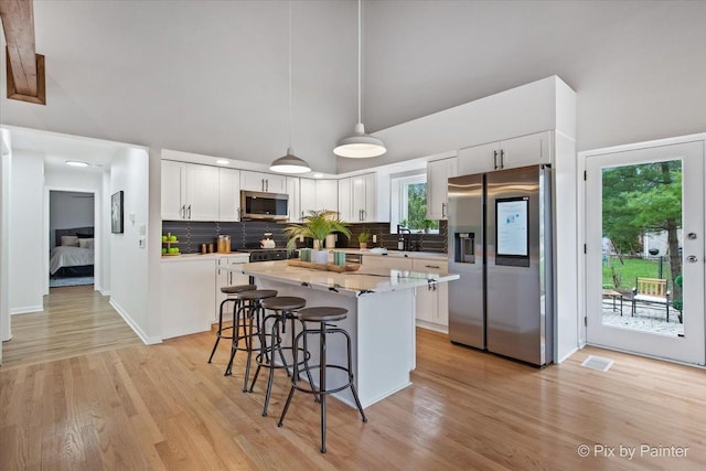 1520 Silver Maple Ct, Naperville, IL 60563 - kitchen featuring appliances with stainless steel finishes, a kitchen bar, tasteful backsplash, a center island, and white cabinets