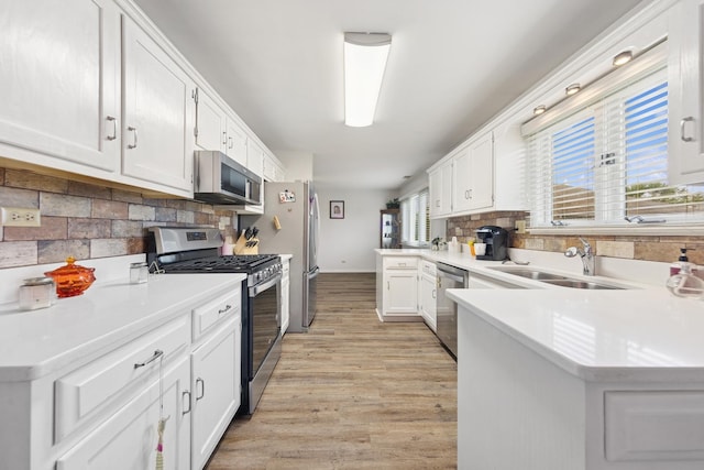2625 Essington Rd Unit 2625, Joliet, IL 60435 - kitchen featuring stainless steel appliances, a sink, decorative backsplash, white cabinetry, and light countertops