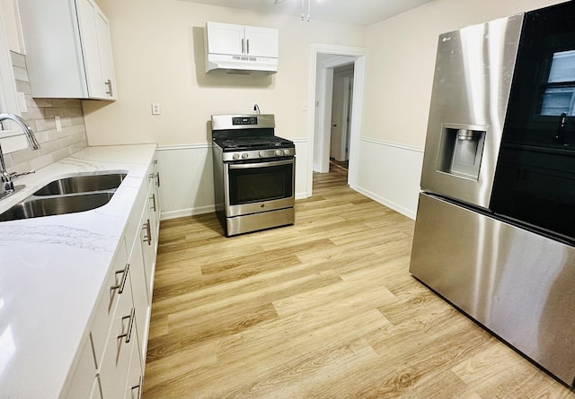 964 S Washington Ave, Kankakee, IL 60901 - kitchen with appliances with stainless steel finishes, a sink, light wood-style floors, light stone counters, and decorative backsplash