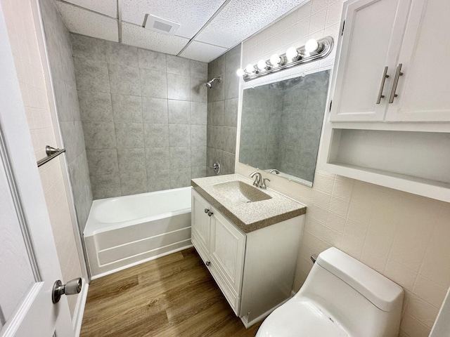 964 S Washington Ave, Kankakee, IL 60901 - bathroom with a paneled ceiling, wood finished floors, vanity, toilet, and tub / shower combination