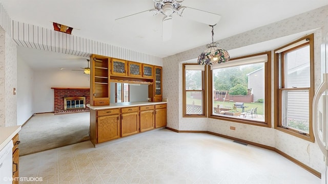 8401 Adbeth Ave, Woodridge, IL 60517 - kitchen with a ceiling fan, wallpapered walls, brown cabinetry, a brick fireplace, and baseboards